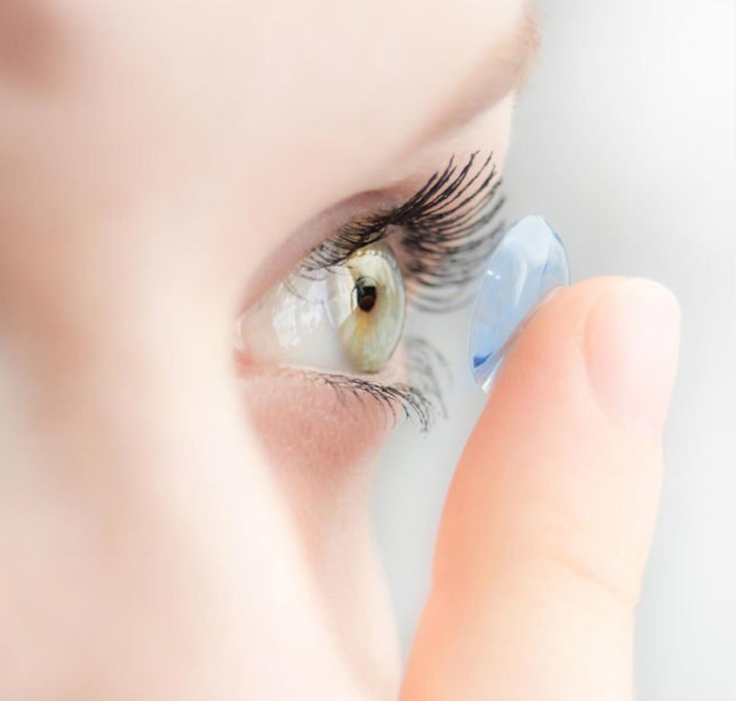 Woman inserting contact lens